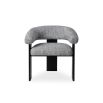 A contemporary armchair by Liang & Eimil with a boucle upholstery and statement legs