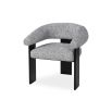 A contemporary armchair by Liang & Eimil with a boucle upholstery and statement legs