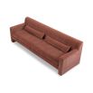 A modern sofa with a statement rust upholstery and scatter cushions