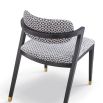 Black and white patterned chair with slanted back legs and brass capped feet