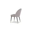 Light grey upholstered dining chair with tapered black legs with brass caps