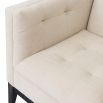 A sophisticated armchair by Liang & Eimil with a neutral upholstery and buttoned design
