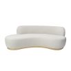A contemporary curved sofa by Liang & Eimil with a boucle upholstery and brushed brass base