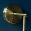 Wall sconce with singular twisted glass globe and brass fixture