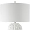 A modern side lamp with a textured white ceramic base and luxury linen shade