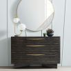 An opulent dresser by Caracole with an ebony finish and golden hardware