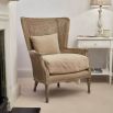 Elegant rattan armchair with linen seat cushion and scatter cushion