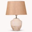 An elegant, terracotta table lamp with a natural, linen lampshade