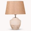 An elegant, terracotta table lamp with a natural, linen lampshade