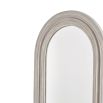 Close up of beautiful, French-inspired wall mirror with arched frame. 