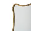 Close-up of unique Eloise mirror with curved frame in aged gold