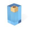 A glamorous candleholder by Jonathan Adler featuring a blue acrylic block fitted with a solid brass candleholder