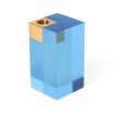 A glamorous candleholder by Jonathan Adler featuring a blue acrylic block fitted with a solid brass candleholder