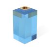 A glamorous candleholder by Jonathan Adler featuring a blue acrylic block fitted with a solid brass candleholder
