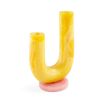 A stylish vase by Jonathan Adler featuring a geometric shape with tones of yellow and pink and a polished marbleized finish