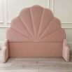 Shell shaped headboard upholstered with pink velvet