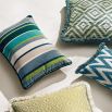 An outdoor, velvet cushion designed with blue and green vertical stripes of different thicknesses.