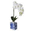 Single faux orchid in patterned blue and white ceramic vase