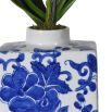 Single faux orchid in patterned blue and white ceramic vase