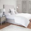 Luxury designer bed with tall headboard and piping detail