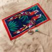 Dark blue beach towel with red border and two parrot design
