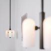Contemporary retro style pendant ceiling light in a black gunmetal brass finish with translucent glass lampshade design
