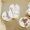 A gorgeous set of four white and speckled gold porcelain plates.