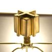 A luxurious sculptural side lamp with layers of solid brass and black lampshade