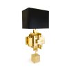 A luxurious sculptural side lamp with layers of solid brass and black lampshade