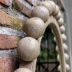 Natural finished round mirror with wooden spheres surrounding the border