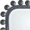 Wall mirror lined with black wooden spheres