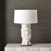 A stylish side lamp by Uttermost with a white ceramic sculptural base and white textured cotton shade