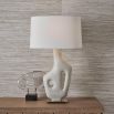 Ivory man-made stone lamp resting on simple antique brass base