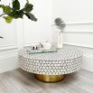 A luxury bone inlay coffee table with a round and geometric design elevated on a brass base