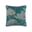 A teal square cushion with tree silhouette details