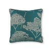 A teal square cushion with tree silhouette details