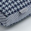 A blue houndstooth knitted outdoor cushion