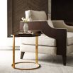A glamorous side table with a round, veneered top and brushed brass base