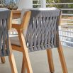 A stylish Scandinavian style outdoor dining chair with a stunning sunbrella cushion upholstery and natural frame