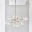 Industrial style 6 arm chandelier in a natural brass finish with 6 clear glass globe bulbs