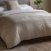 Beige quilted bedspread with black stitching
