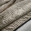 Beige quilted bedspread with black stitching