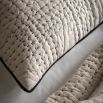 Beige quilted cushion with black stitching