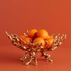 A luxury brass bowl by Jonathan Adler with a chic coral design 