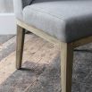 Grey upholstered dining chair with warm oak frame