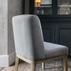 Grey upholstered dining chair with warm oak frame