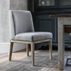 Grey upholstered dining chair with warm oak frame