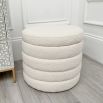 A luxurious boucle cream upholstered ottoman with storage space