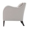 A stylish armchair with a grey upholstery, chic curves and wavy armrests 