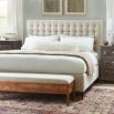 A sumptuous bed with a padded deep buttoned back and cream finish